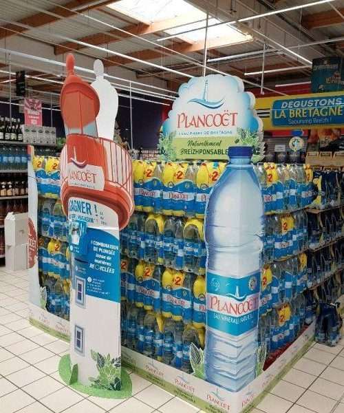 théâtralisation îlot promotionnel en plv carton : coin de palette silhouetté géant, totem silhouetté géant, fronton sur mât